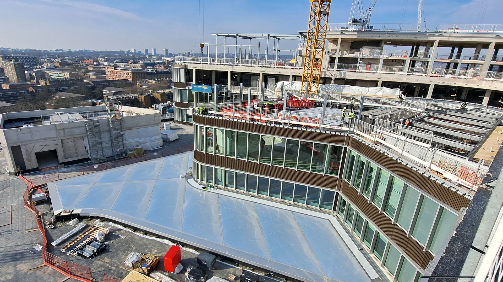 Construction workers wearing yellow safety helmets, looking at blueprints